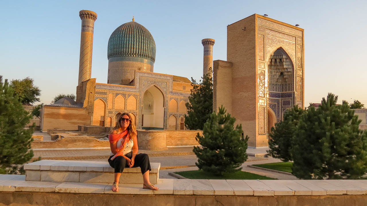 Flor frente al Mausoleo de Amir Timur, cuya fachada tiene un color anaranjado proporcionado por el atardecer.
