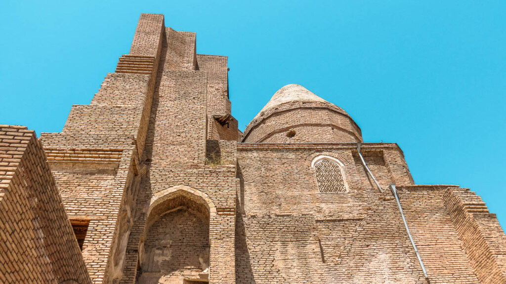 Dorus Saodat Complex, a photo taken from below the imposing brick wall. You can see its dome, which is neither coloured nor rounded. 