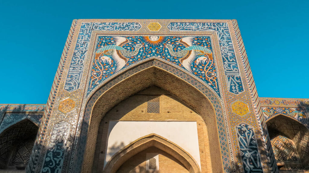Detalles arquitectónicos de la fachada de la Madrasa de Nodir Devon Begi, el rostro humano en el sol, y su preciosa decoración en tonos de azul, verde y dorado.