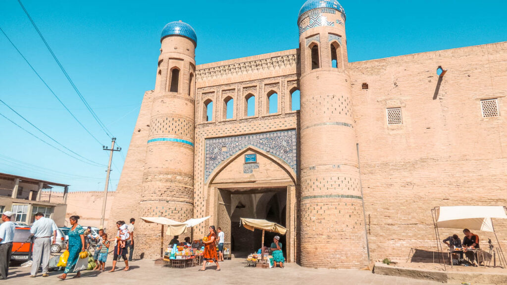 Puerta Este de Acceso a Ichon Qala en Khiva, se puede observar puestos callejeros y gente que viene con sus compras de lo s bazares.