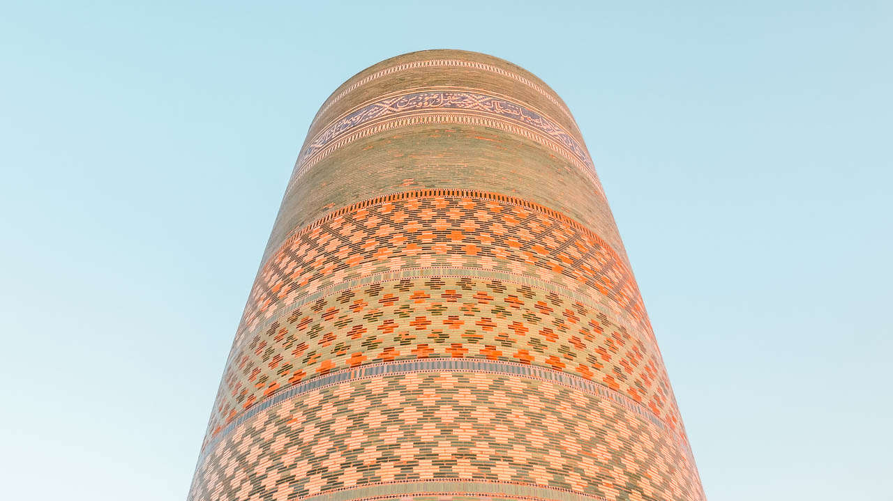 Minarete Kalta Minor desde abajo, bien colorido y con un cielo celeste de atardecer de fondo.